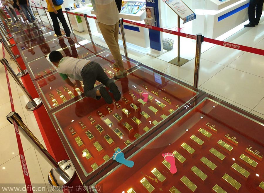 Ni?os juegan sobre la pasarela de lingotes de oro en un centro comercial de Yichang, Hubei, el 21 de septiembre de 2014. [Foto/IC]