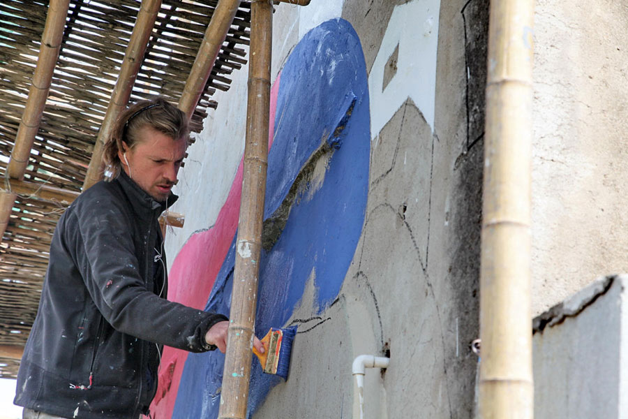 El artista francés Julien Seth Malland pinta una pared en una aldea del pueblo Fengjing en el distrito Jinshan de Shanghai. El parisino de 42 a?os pintará 10 obras en el pueblo en las próximas dos o tres semanas. [Foto/Xinhua] 