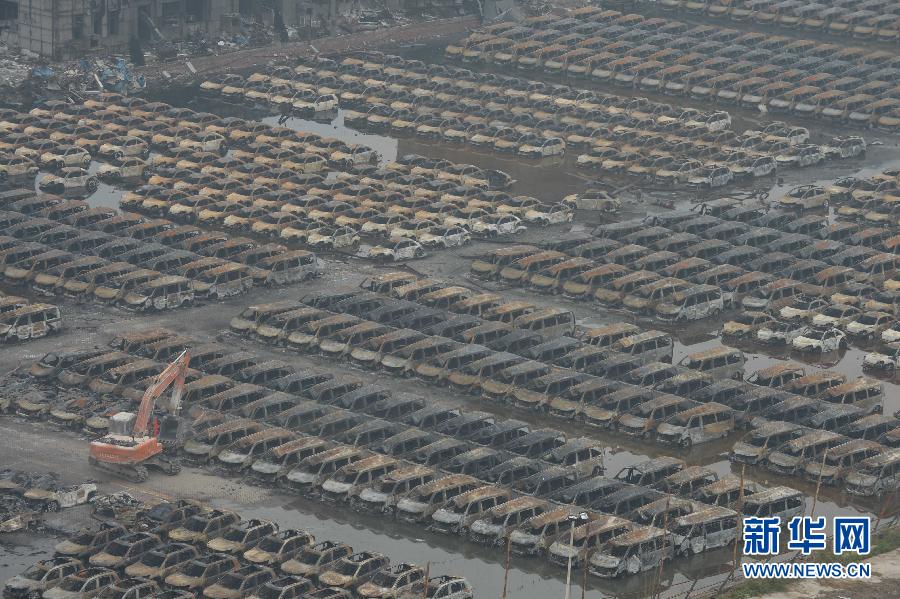 El servicio de rescate y varias máquinas retiran los vehículos calcinados tras la explosión de Tianjin, el 20 de agosto. [Foto/Xinhua]