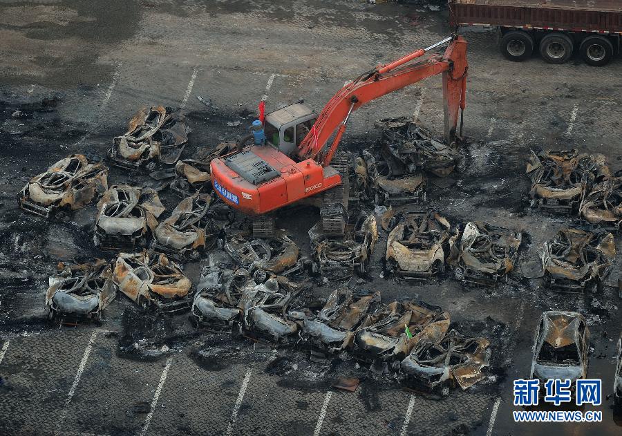 El servicio de rescate y varias máquinas retiran los vehículos calcinados tras la explosión de Tianjin, el 20 de agosto. [Foto/Xinhua]