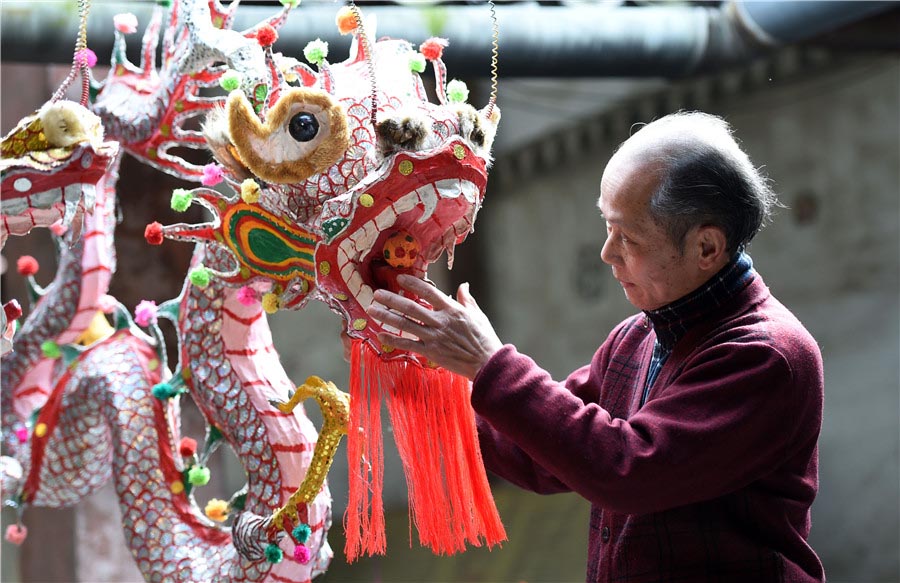 Zou Yute adorna un farolillo de dragón en el condado Binyang, región autónoma Zhuang de Guangxi, el 16 de febrero de 2016. [Foto/Xinhua]