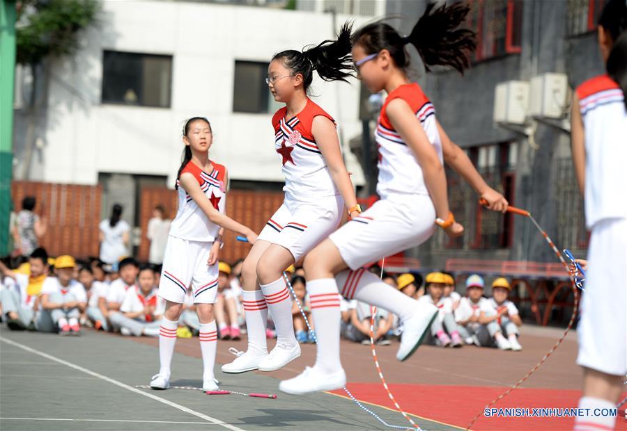 Ni?os brincan la cuerda durante una celebración para recibir el próximo Día del Ni?o, en la Escuela Primaria Fuxue Hutong, en Beijing, capital de China, el 30 de mayo de 2016. (Xinhua/Luo Xiaoguang)