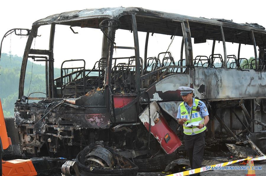 Un policía de tránsito examina un sitio del accidente en el condado de Yizhang, en la provincia central de Hunan, en China, el 26 de junio de 2016. Un incendio que redujo a un autobús turístico a una estructura carbonizada el domingo por la ma?ana ha provocado la muerte de al menos 35 personas, incluidos dos ni?os, en la provincia central china de Hunan, confirmaron las autoridades locales. El accidente se produjo hacia las 10:20 horas, cuando el autobús chocó contra las barreras de protección en una autopista de Yizhang. (Xinhua/Long Hongtao)