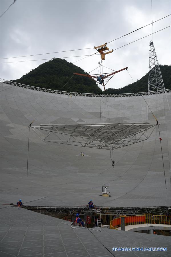 El último panel triangular del reflector del Telescopio de Apertura Esférica de 500 metros, o "FAST", es colocado en el condado de Pingtang, provincia de Guizhou, en el suroeste de China, el 3 de julio de 2016. La instalación del "FAST", el radiotelescopio más grande del mundo, fue completada el domingo por la ma?ana al colocar el último de los 4,4450 paneles en el centro del gran plato. Los científicos comenzarán las pruebas de depuración y observación del FAST. (Xinhua/Ou Dongqu)