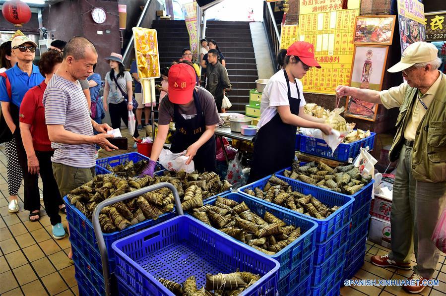 TAIPEI, mayo 29, 2017 (Xinhua) -- Personas compran "zongzi", dumplings con forma de pirámide elaborados con arroz glutinoso, envueltos en hojas de bambú o ca?a, en un mercado en Taipei, Taiwan, en el sureste de China, el 29 de mayo de 2017. (Xinhua/Liu Junxi)