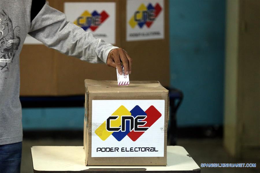 Una persona deposita su voto en una urna electoral durante las elecciones regionales, en un centro de votación en Petare, estado Miranda, Venezuela, el 15 de octubre de 2017. Venezolanos empezaron a concentrarse desde las 6:00 hora local de este domingo en los principales centros de votación habilitados por el Poder Electoral, para elegir a los 23 gobernadores que regirán por los próximos cuatro a?os. (Xinhua/Fausto Torrealba/AVN)