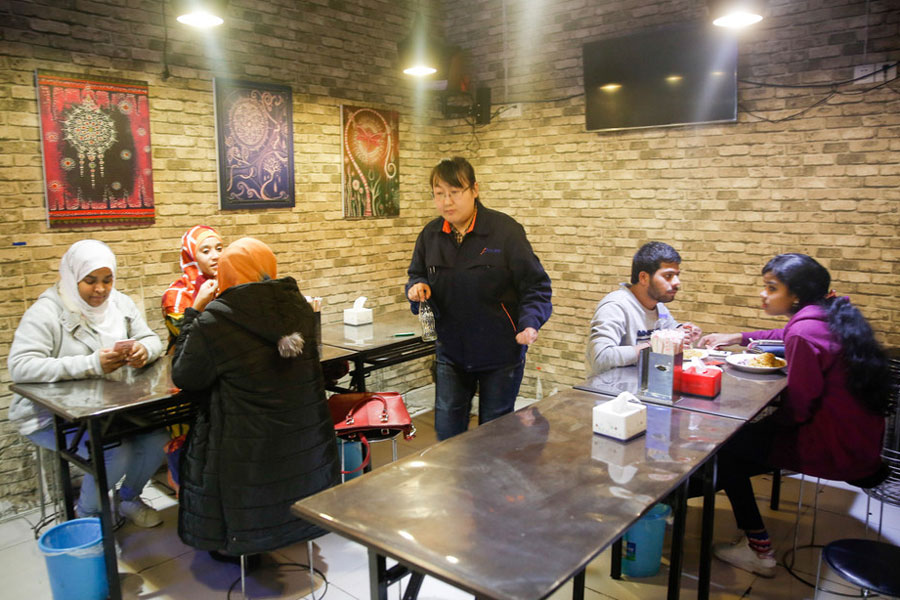 Si Shaojie y su esposa sirven en la Fonda Desi, ubicada en la ciudad de Zhengzhou, provincia de Henan, 9 de Noviembre del 2017. 