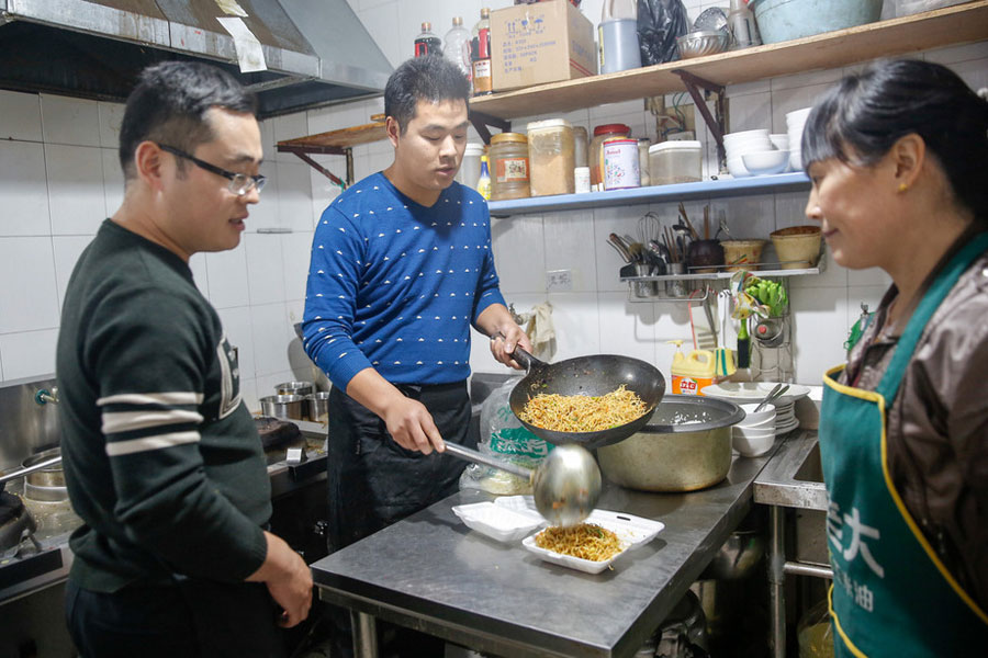 Si Shaojie (a la izquierda) y su personal en la Fonda Desi, ubicada en la ciudad de Zhengzhou, provincia de Henan, 9 de Noviembre del 2017.