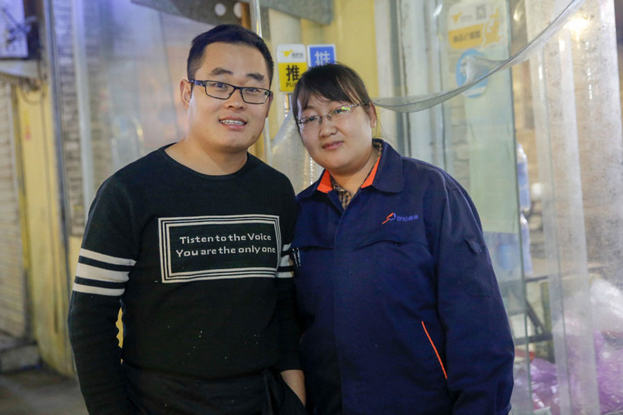 Si Shaojie toma una foto con su esposa delante de su restaurante Desi alimentos en la ciudad de Zhengzhou, provincia de Henan en China Central, Nov 9, 2017. 