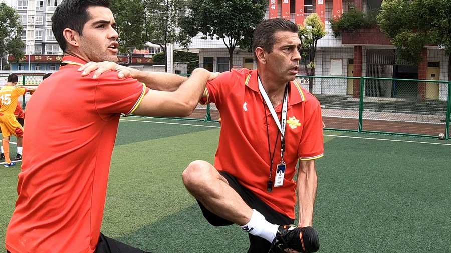 El entrenador espa?ol José (derecha) y el chileno Piri estrenan a ni?os chinos en la escuela Zhenghua en la ciudad de Kaili, suroeste de China.