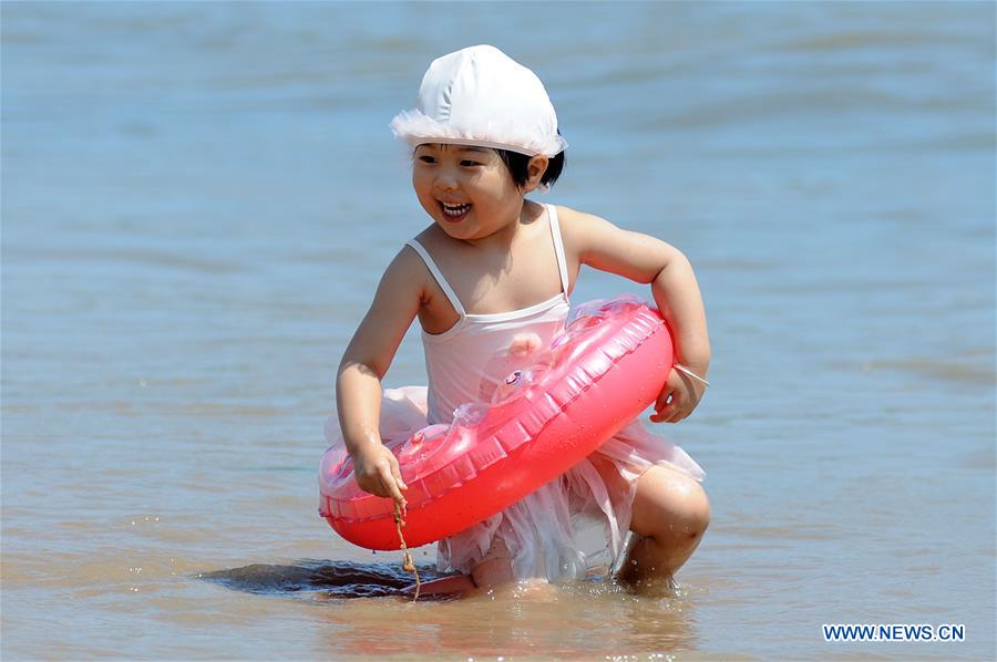 La gente juega en el balneario de Qingdao, E Shandong de China