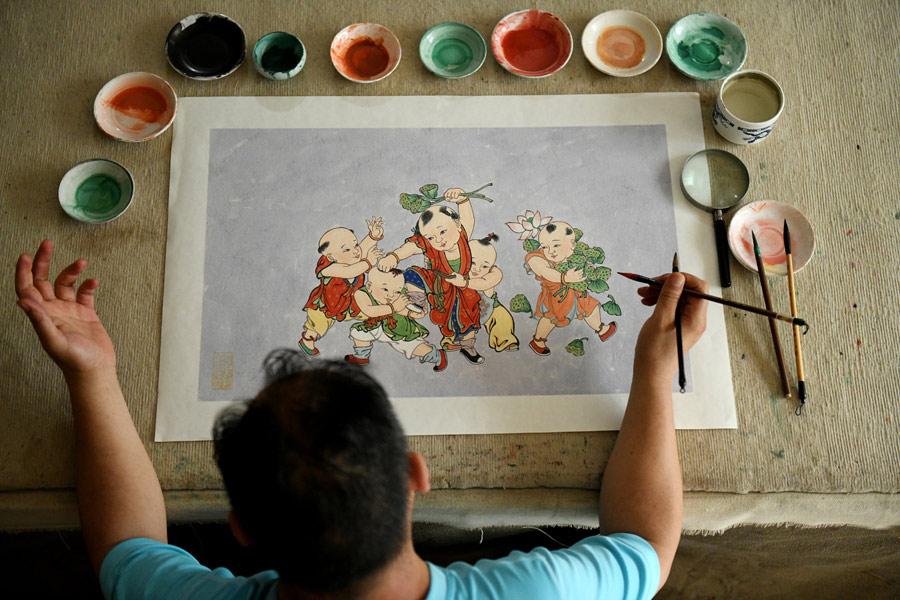 En su estudio, Yao Shulong dibuja una pintura china tradicional de a?o nuevo usando técnicas murales, 24 de julio del 2018. (Foto: Xinhua)