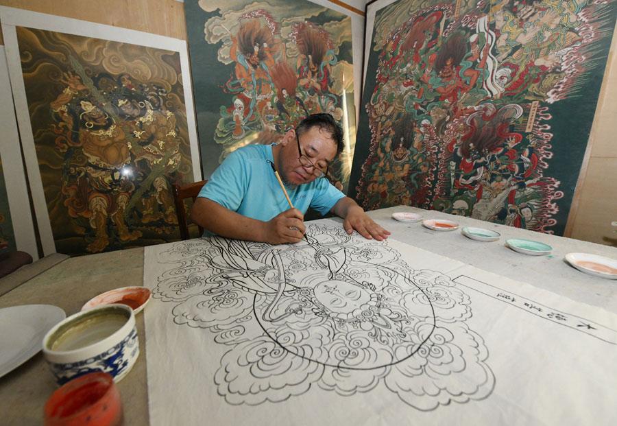 En su estudio, Yao Shulong dibuja una pintura china tradicional de a?o nuevo usando técnicas murales, 24 de julio del 2018. (Foto: Xinhua)