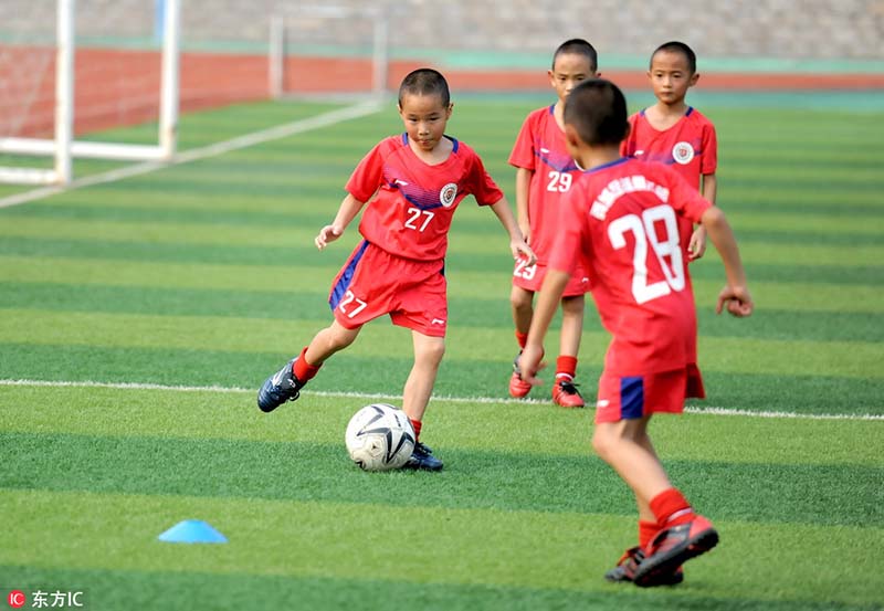 Los cuatrillizos juegan al fútbol en Jinan, provincia de Shandong, 2 de agosto del 2018. [Foto: IC]