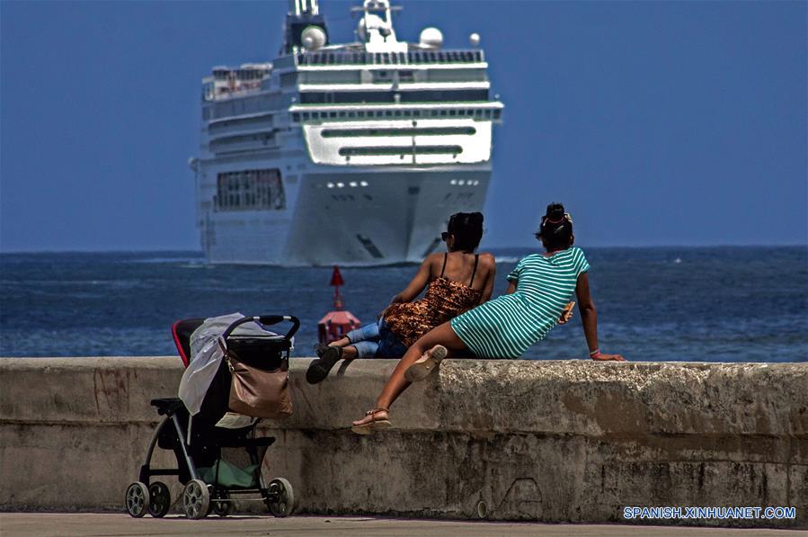 Imagen del 13 de marzo de 2018 de dos mujeres observando la entrada de un crucero a la bahía de La Habana, Cuba. La industria turística cubana, el sector más dinámico de la economía de la isla, se ha desacelerado en lo que va del a?o como resultado de las medidas restrictivas de la administración del presidente estadounidense Donald Trump. Esta semana, el Ministerio de Turismo de Cuba (MINTUR) informó de la llegada de 3 millones de vacacionistas, una cifra lograda 16 días más tarde que en 2017, la cual confirmó la caída del ritmo de arribos a la isla. Desde 2012, el arribo de vacacionistas extranjeros a Cuba ha mantenido una tasa de crecimiento promedio del 13 por ciento, lo que convirtió a la llamada "Industria del ocio" en una de las principales fuentes de ingresos de la economía cubana. El a?o pasado, la isla logró la cifra histórica de 4 millones 689.000 visitantes foráneos, cifra que significó un incremento del 16,2 por ciento de turistas respecto al a?o anterior. (Xinhua/Joaquín Hernández)