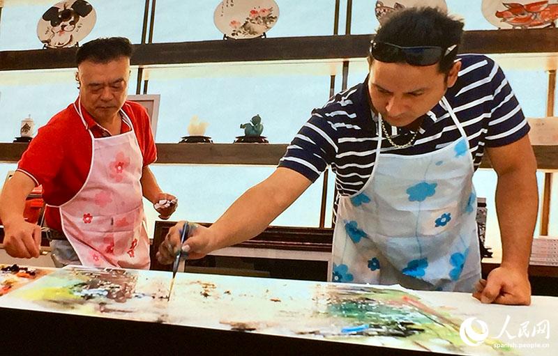 El artista chino Wu Xiaolin y el cubano Li Domínguez Fong durante la preparación de la obra del sobre postal artístico sino-cubano conmemorativo por el 70o aniversario de la fundación de la República Popular China, Beijing, 6 de julio del 2019. (Foto: YAC)