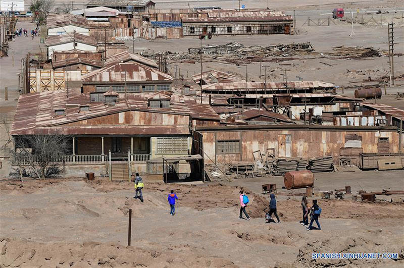 Imagen del 24 de julio de 2019 de turistas recorriendo la oficina salitrera Santiago Humberstone, en la comuna de Pozo Almonte de la provincia del Tamarugal, en la región de Tarapacá, Chile. Construidas en medio del desierto chileno de Atacama, el más árido del mundo, las oficinas salitreras de Santiago Humberstone y Santa Laura celebran hoy en día haber dejado la Lista del Patrimonio Mundial en Peligro de la Organización de las Naciones Unidas para la Educación, la Ciencia y la Cultura (UNESCO, por sus siglas en inglés), en la que estuvieron durante 14 a?os. (Xinhua/Jorge Villegas)