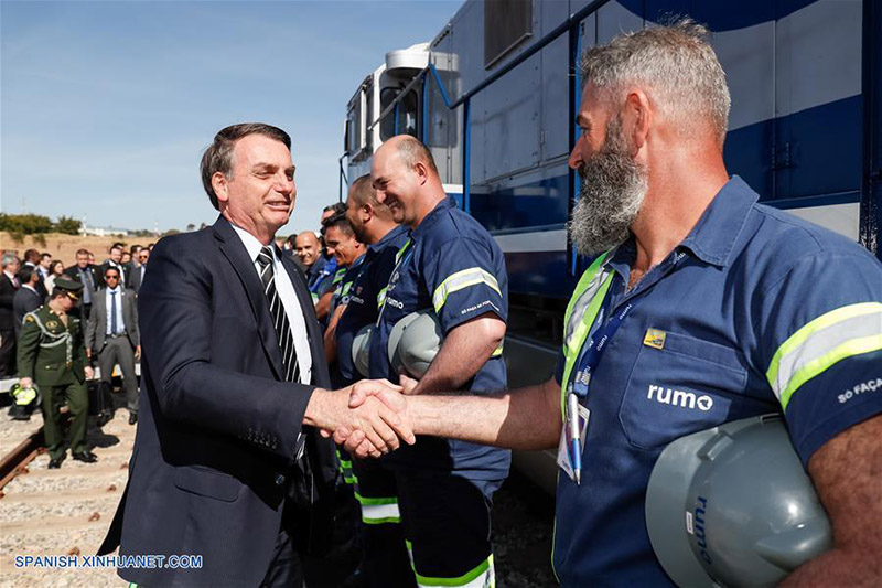 Imagen cedida por la Presidencia de Brasil, del presidente brasile?o, Jair Bolsonaro (i-frente), estrechando la mano con un trabajador durante la ceremonia de firma de una concesión ferroviaria, en Anápolis, estado de Goiás, Brasil, el 31 de julio de 2019. Bolsonaro participó el miércoles en Anápolis, estado de Goiás, en la firma del contrato de concesión del Ferrocarril Norte-Sur, el cual irá de Porto Nacional, Tocantins a Estrela D'Oeste, Sao Paulo. (Xinhua/Alan Santos/Presidencia de Brasil)