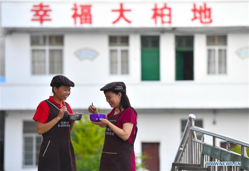 Liu Lihong cena con sus comidas después del trabajo en el patio del gobierno local. Dabaidi, Ruijin, provincia de Jiangxi, 19 de agosto del 2019 (Foto: Xinhua / Lan Hongguang)