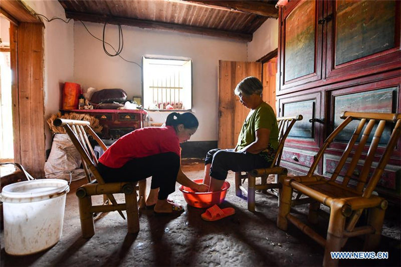 Liu Lihong ayuda a su suegra a ba?arse. Dabaidi, Ruijin, provincia de Jiangxi, 19 de agosto del 2019 (Foto: Xinhua / Lan Hongguang)