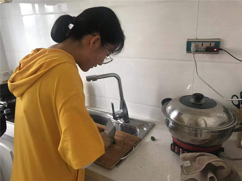 Liu Ximeng cocina en el apartamento que alquila para cuidar a su madre en Harbin, capital de la provincia de Heilongjiang, noreste de China, el 5 de septiembre. [Foto proporcionada a chinadaily.com.cn]