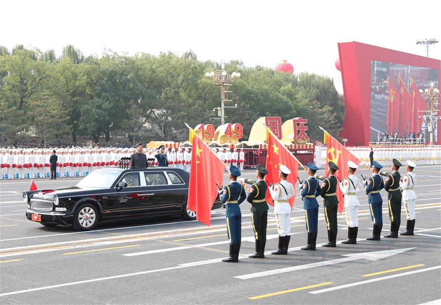 El presidente chino, Xi Jinping, también secretario general del Comité Central del Partido Comunista de China (PCCh) y presidente de la Comisión Militar Central, rinde honores a las banderas del PCCh, la nación y del Ejército Popular de Liberación al inicio de su pase de revista a las fuerzas armadas durante las celebraciones por el 70o aniversario de la fundación de la República Popular China en Beijing, capital de China, el 1 de octubre de 2019. (Xinhua/Ding Haitao)