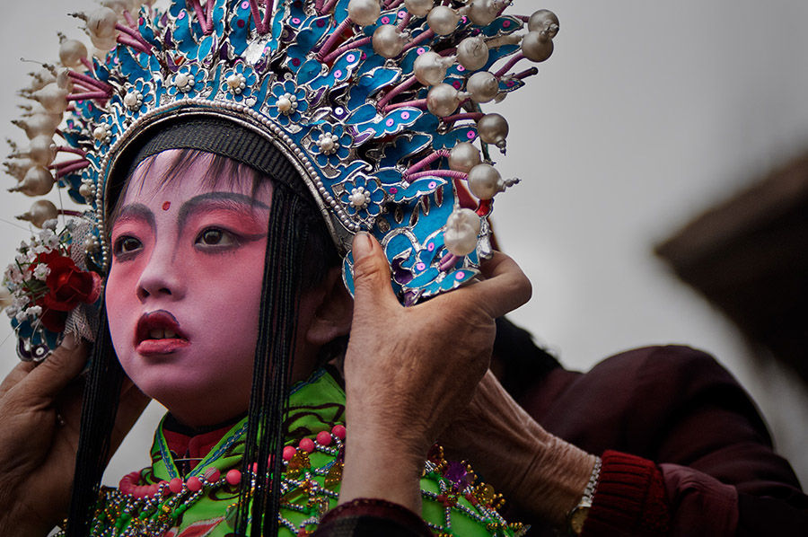 Un ni?o se prepara para una actuación de Shehuo. [Foto: Wu Xiaopeng/cpanet.org.cn]