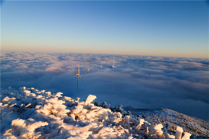 Salida del sol entre mares de nubes en un paisaje nevado.  (Fotos: Chen Chunzhi/para chinadaily.com.cn)