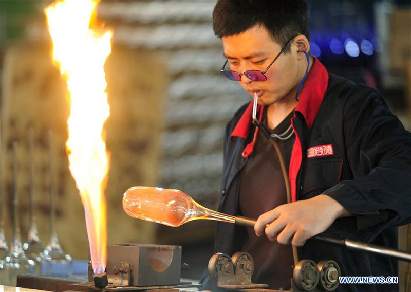 Un trabajador funde el vidrio en el Museo del Vidrio en la ciudad de Hejian, provincia de Hebei, en el norte de China, el 18 de diciembre de 2019.