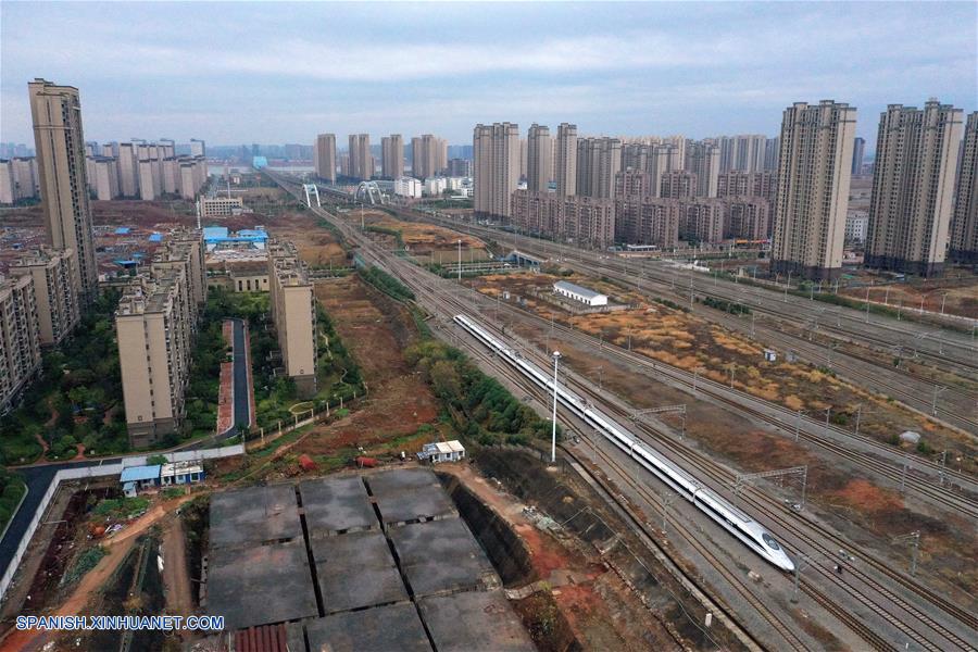 Vista aérea del 26 de diciembre de 2019 del primer tren de alta velocidad G5025 saliendo de la Estación Nanchang Oeste después de la inauguración del ferrocarril de alta velocidad Nanchang-Ganzhou, en Nanchang, capital de la provincia de Jiangxi, en el este de China. Un ferrocarril de alta velocidad inició operaciones el jueves en la provincia china de Jianxi, enlazando la capital provincial Nanchang con la "cuna de la revolución china" Jinggangshan y la zona rica en tierras raras de Ganzhou. La vía de 418 kilómetros de largo está dise?ada para una velocidad de 350 km por hora y acorta el antiguo viaje por tren de cuatro horas a menos de dos horas. (Xinhua/Peng Zhaozhi)