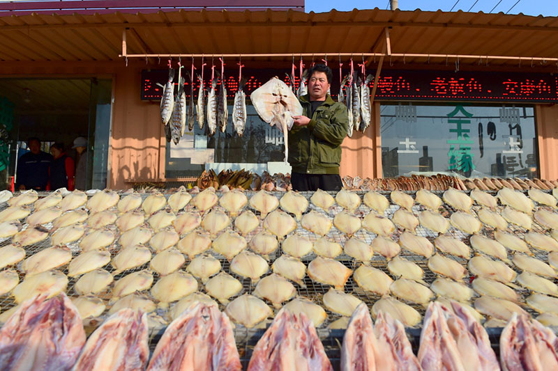 Imagen de pescado salado seco en la entrada de una tienda en el vecindario Wanggezhuang de Qingdao, en la provincia de Shandong, este de China. Se trata de una estampa típica del duodécimo mes del calendario lunar chino, conocido como layue en chino. [Fotos de Wang Hua / para chinadaily.com.cn]