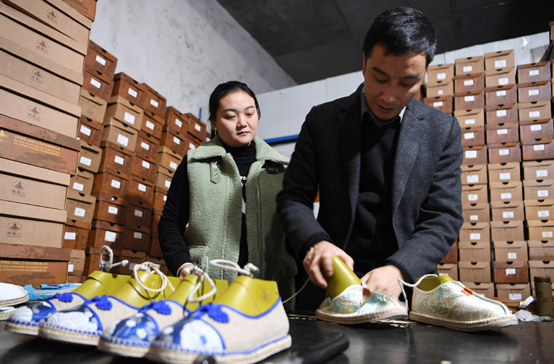 Niu Junjun y su esposa, Guo Juan, revisan los zapatos de cá?amo en su fábrica en el condado Gangu, provincia de Gansu, noroeste de China, el 10 de enero de 2020. [Foto / Xinhua]