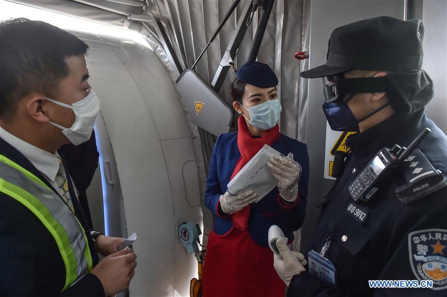 BEIJING, 2 febrero, 2020 (Xinhua) -- Imagen del 1 de febrero de 2020 del policía Wu Shengzao (d), preguntando a empleados de una aerolínea sobre la condición de los pasajeros en el Aeropuerto Internacional Daxing en Beijing, capital de China. Las autoridades chinas han endurecido las medidas para combatir la epidemia del nuevo coronavirus a medida que el número de personas que salen a carretera y regresan a trabajar aumenta después de las vacaciones del Festival de Primavera. Wu Shengzao, de 34 a?os de edad, es un policía que trabaja en el Aeropuerto Internacional Daxing. Durante la batalla antivirus, Wu y sus colegas pasaron días patrullando el aeropuerto, midiendo la temperatura de los pasajeros y controlando sus condiciones y necesidades. (Xinhua/Peng Ziyang)