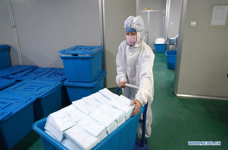 NANCHANG, 2 febrero, 2020 (Xinhua) -- Imagen del 1 de febrero de 2020 de un trabajador trasladando mascarillas en un taller de una compa?ía en el distrito Jinxian, provincia de Jiangxi, en el este de China. Para ayudar a combatir el brote de neumonía causada por el nuevo coronavirus, los trabajadores de muchas compa?ías de material médico se apresuraron a trabajar antes de lo previsto. (Xinhua/Wan Xiang)