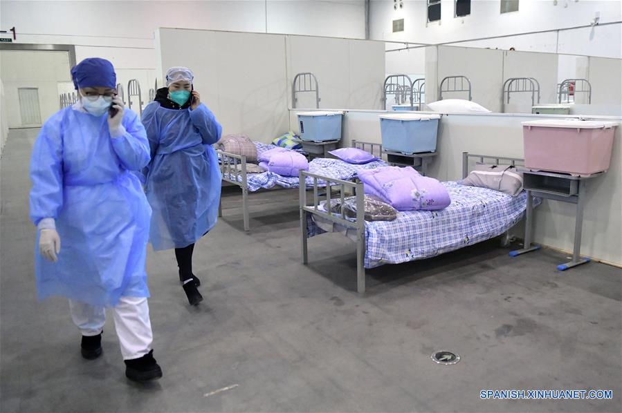 WUHAN, 8 febrero, 2020 (Xinhua) -- Trabajadores médicos pasan por la unidad de enfermería B del "Wuhan Livingroom" en Wuhan, provincia de Hubei, en el centro de China, el 8 de febrero de 2020. El complejo de edificios culturales denominado "Wuhan Livingroom," que se convirtió en hospital para recibir pacientes infectados con el nuevo coronavirus, está dise?ado para alojar 2,000 camas. La unidad de enfermería B del hospital está lista, mientras la unidad A se ha puesto en uso antes. (Xinhua/Li He)