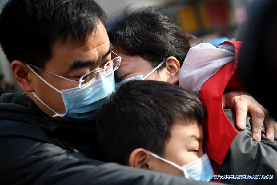 XI'AN, 8 febrero, 2020 (Xinhua) -- Long Junhong (d, arriba), integrante de un equipo médico del Hospital Segundo Afiliado de la Universidad Xi'an Jiaotong, abraza a su esposo y su hijo antes de partir a la provincia de Hubei en Xi'an, capital de la provincia Shaanxi, en el noroeste de China, el 8 de febrero de 2020. Un equipo médico compuesto por 130 integrantes del Hospital Segundo Afiliado de la Universidad Xi'an Jiaotong partió de Xi'an para la provincia de Hubei el sábado para ayudar a los esfuerzos de control del nuevo coronavirus allá. (Xinhua/Li Yibo)