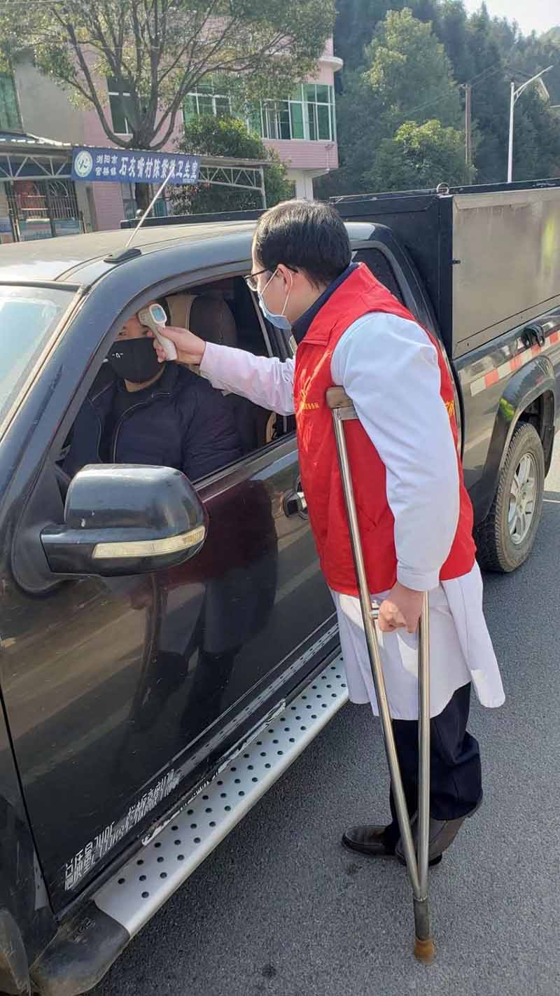 Zhang Ruilin verifica la temperatura de un conductor que pasa por la estación de monitoreo de la ciudad de Guanqiao.  [Foto: proporcionada a chinadaily.com.cn]