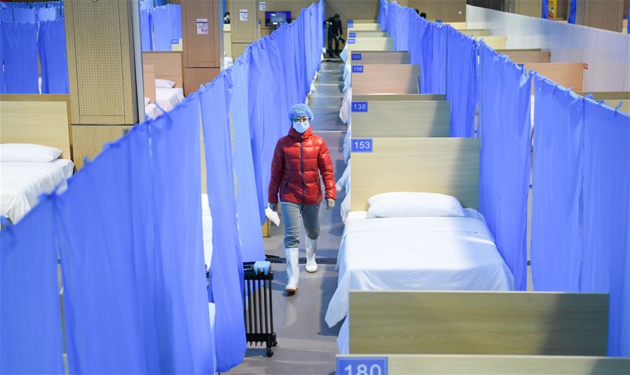 WUHAN, 14 febrero, 2020 (Xinhua) -- Una trabajadora revisa las salas del hospital provisional Jiangxia, en Wuhan, capital de la provincia de Hubei, en el centro de China, el 14 de febrero de 2020. Se espera que el hospital provisional Jiangxia, un hospital de 400 camas convertido de un centro deportivo al aire libre, reciba a los pacientes de neumonía COVID-19 con síntomas leves el viernes. El hospital en el primer hospital provisional que adoptará principalmente el tratamiento de medicinas tradicionales chinas para curar a los pacientes. (Xinhua/Cheng Min)