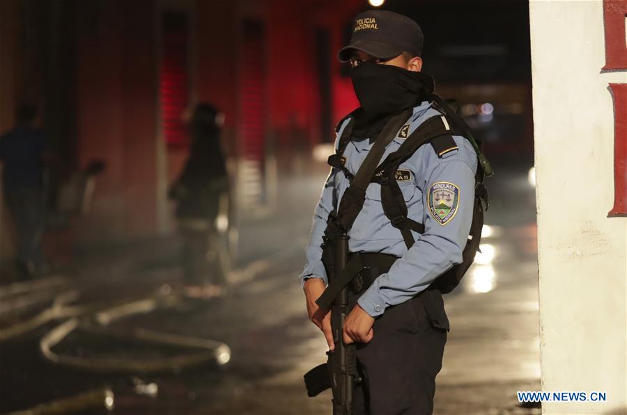 TEGUCIGALPA, 16 febrero, 2020 (Xinhua) -- Un policía vigila mientras bomberos trabajan para apagar un incendio de locales comerciales en el centro de Tegucigalpa, Honduras, el 16 de febrero de 2020. Un incendio en el casco histórico de Tegucigalpa, capital de Honduras, arrasó cinco negocios la tarde del domingo, sin que se reportaran víctimas mortales, informó el Cuerpo de Bomberos. (Xinhua/Rafael Ochoa)