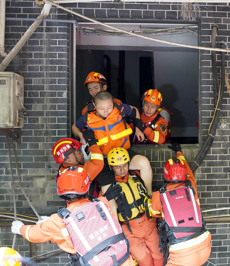 Bomberos rescatan a los residentes atrapados en un hotel el jueves durante las inundaciones en Chongqing. [Foto: Xinhua]