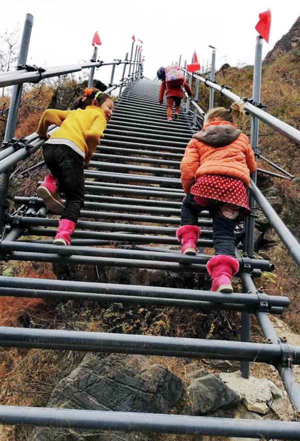 Foto tomada el 5 de mayo de 2020 muestra a un aldeano que regresa a la "aldea del acantilado" a través de las escaleras de acero recién construidas. (Pueblo en Línea / Laobing)