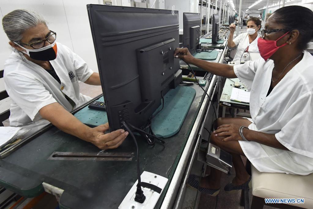 Imagen del 21 de mayo de 2021 de trabajadoras laborando en el ensamblaje de televisores en los talleres de la Empresa Industria Electrónica "Comandante Camilo Cienfuegos", en La Habana, capital de Cuba. Cuba espera dar un impulso a la expansión de la televisión digital con norma china mediante la producción este a?o de 318.000 cajas decodificadoras, en el contexto de la pandemia de la enfermedad del nuevo coronavirus (COVID-19) y los efectos de las sanciones económicas del bloqueo de Estados Unidos contra el país. (Xinhua/Joaquín Hernández)