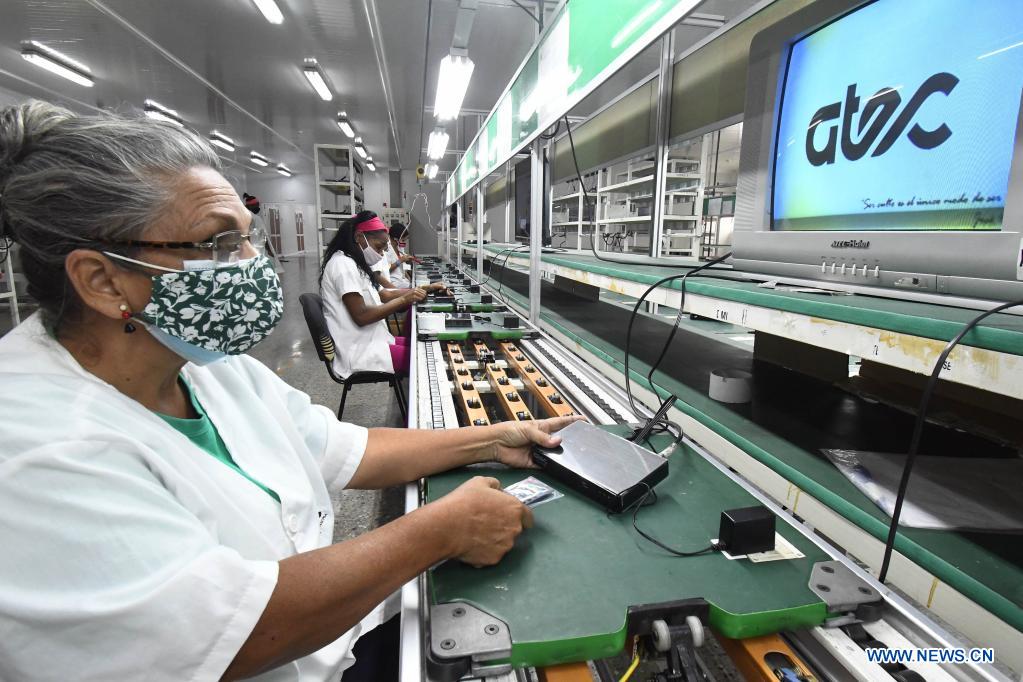 Imagen del 21 de mayo de 2021 de trabajadoras ensamblando cajas decodificadoras usadas para la televisión digital con norma china en los talleres de la Empresa Industria Electrónica "Comandante Camilo Cienfuegos", en La Habana, capital de Cuba. Cuba espera dar un impulso a la expansión de la televisión digital con norma china mediante la producción este a?o de 318.000 cajas decodificadoras, en el contexto de la pandemia de la enfermedad del nuevo coronavirus (COVID-19) y los efectos de las sanciones económicas del bloqueo de Estados Unidos contra el país. (Xinhua/Joaquín Hernández)