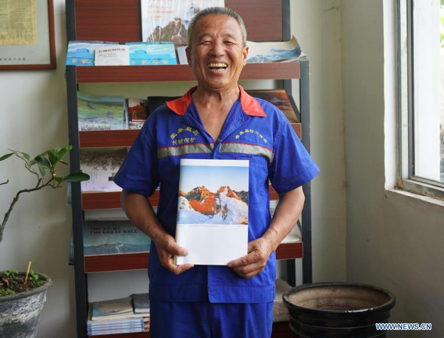 Zhang Heshan muestra un libro sobre la sección de la Gran Muralla de Chengziyu, Qinhuangdao, provincia de Hebei, 7 de julio del 2021. (Foto: Xinhua/ Jin Haoyuan)