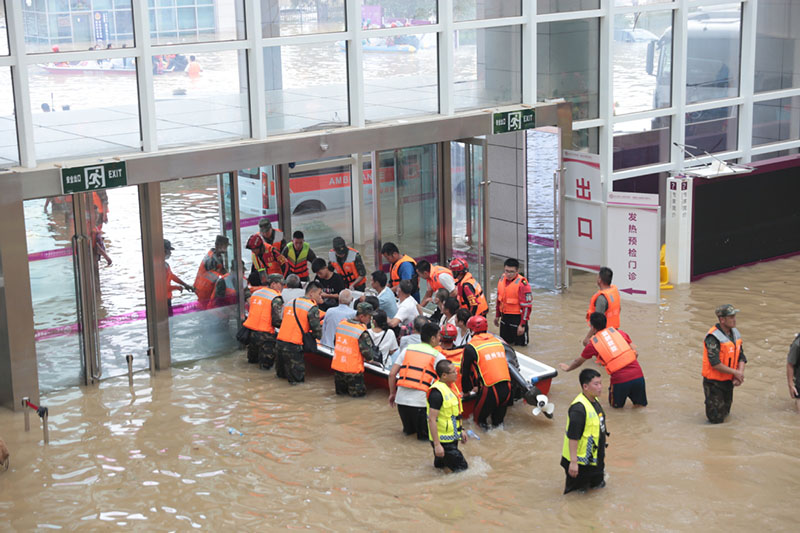 Los equipos de rescate ayudan a trasladar a pacientes varados con un bote inflable en el Hospital Cardiovascular Central de China de Fuwai en Zhengzhou, capital de la provincia de Henan, el 22 de julio de 2021. [Foto de Wang Jing / chinadaily.com.cn]