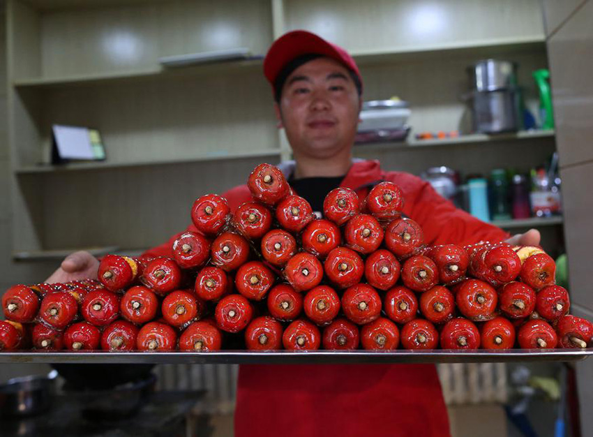 Vendedor de Bingtanghulu, espinos recubiertos de azúcar, en la provincia de Jilin. [Foto: Baishi/ Chinadaily.com.cn]