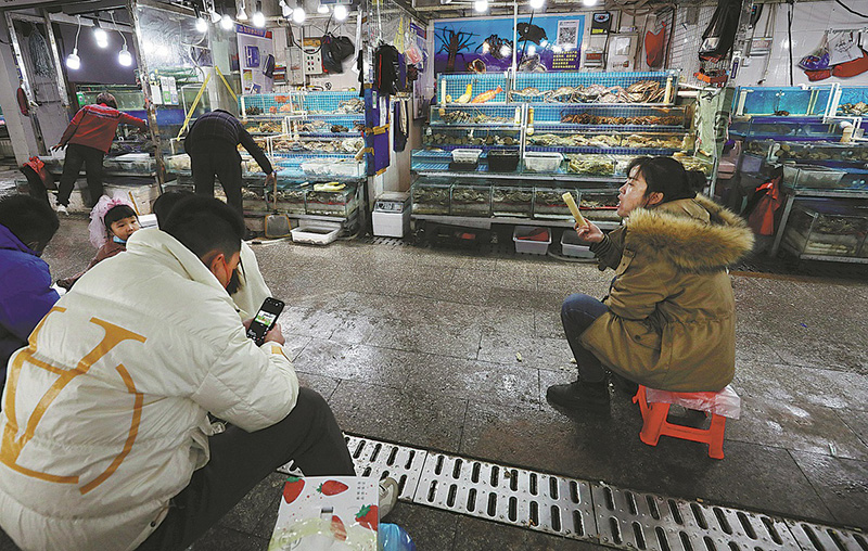 Los peque?os minoristas esperan a los clientes en el Mercado Jingshen de Productos del Mar, 19 de noviembre. (Foto: Zhu Xingxin/ China Daily)