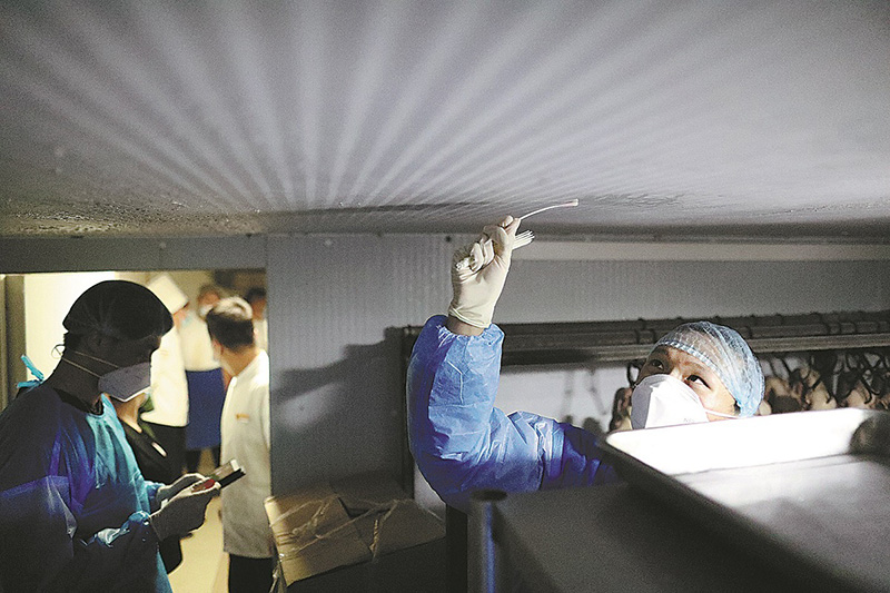 Miembros de un equipo de prueba de la Academia China de Inspección y Cuarentena trabajan en el congelador de un restaurante en Beijing el 9 de septiembre. (Foto: Zhu Xingxin/ China Daily)