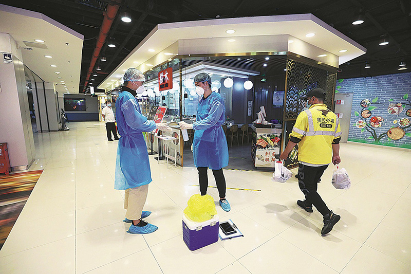 Después de revisar los alimentos congelados importados en un restaurante de Beijing, los miembros del equipo de prueba se desinfectan, 9 de septiembre. (Foto: Zhu Xingxin/ China Daily)