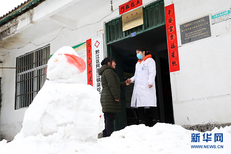 Shuai Xiaoyun, a la derecha, despide a un aldeano después de su cita, el 10 de febrero de 2022. [Foto: Xinhua]